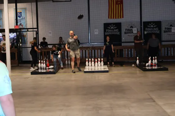 Players at the lanes with pins set up ahead of a throw