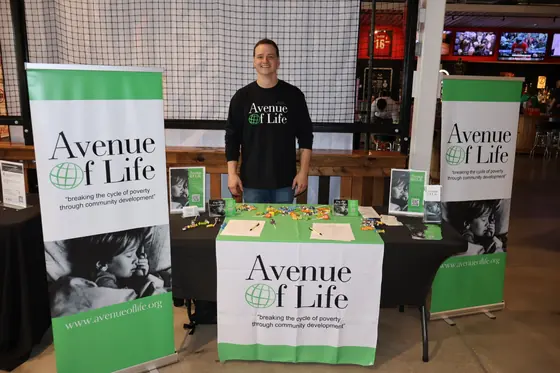 The Avenue of Life table with banners and a volunteer