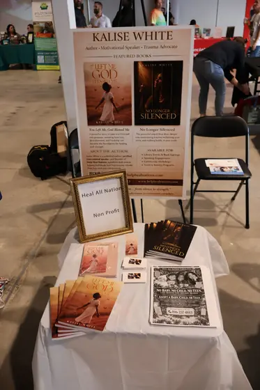 An author's table with books and a standing banner
