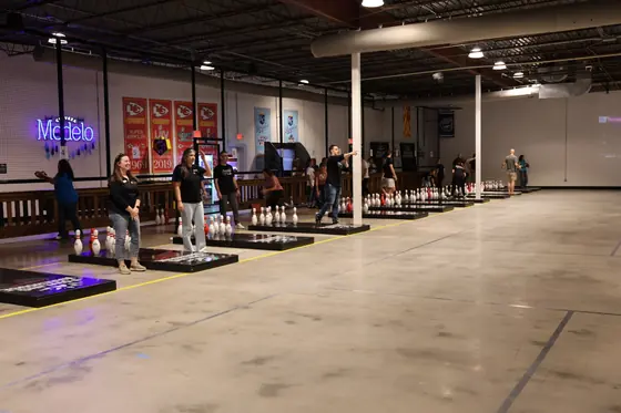 Fowling lanes lit with neon before play, tables beyond