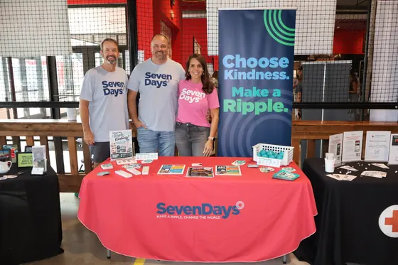 Three volunteers at the SevenDays table