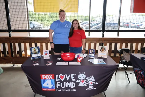 Two volunteers at the Love Fund for Children table