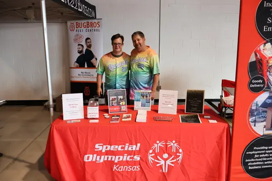 Two volunteers in tie dye shirts at the Special Olympics Kansas table
