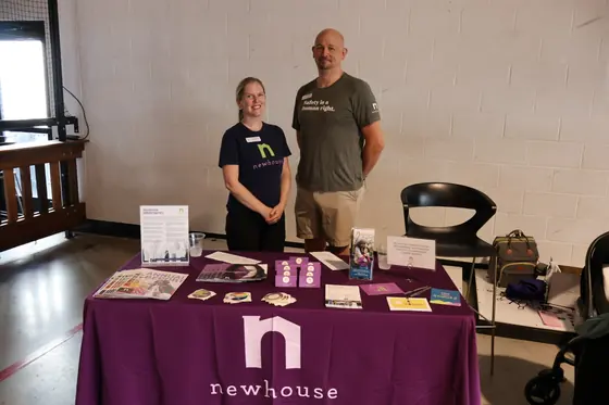 Two volunteers at the Newhouse table