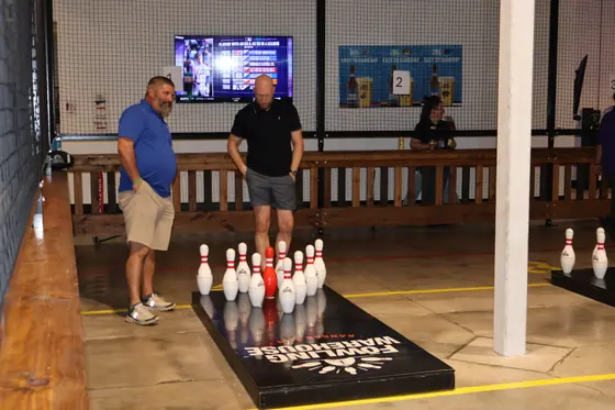 Two players setting up pins on a lane