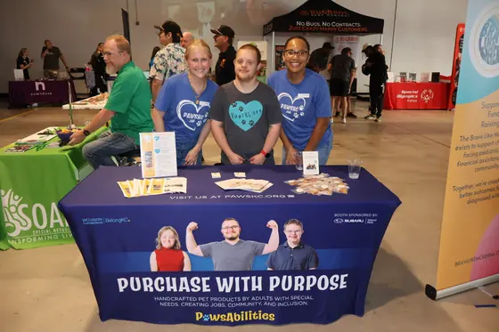 Four volunteers at the Purchase with Purpose table