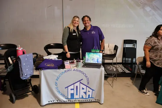 Two volunteers at the Friends of Recovery Association table