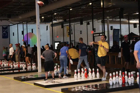 Players at the lanes as a football flies toward the pins