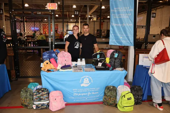 A table stacked with backpacks