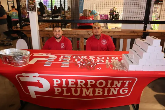 Two team members behind the Pierpoint Plumbing table
