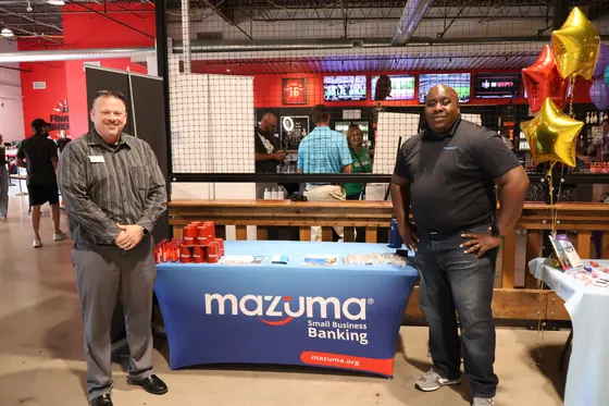 Two men at the Mazuma Credit Union table