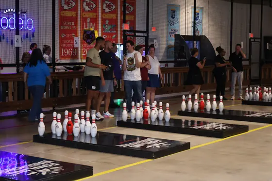 Players at the lanes with a row of pins standing