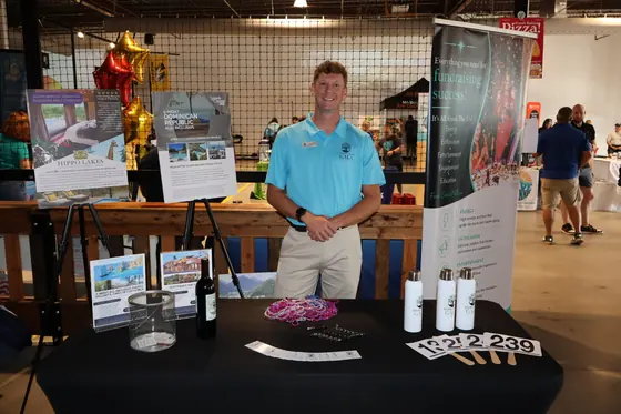 A man at a table with framed photo displays