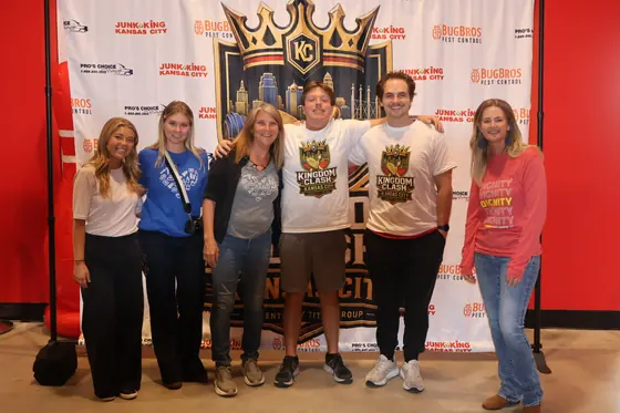 Six people posing in front of the Kingdom Clash backdrop