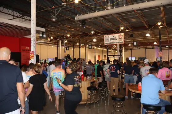A crowd gathered around the bar tables