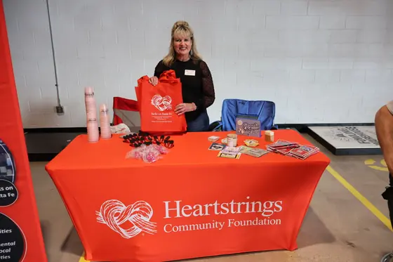 A volunteer at the Heartstrings Community Foundation table